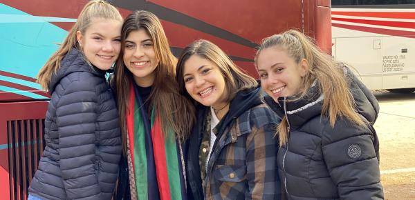 Students smiling by bus